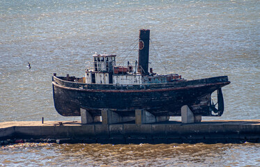 Montevideo, Uruguay- December 18, 2008: Closeup of old wooden vessel raised on pedestal on harbor...