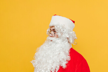Portrait of santa claus in profile on yellow background, looking aside at blank space with serious face. Isolated. Christmas and New Year.