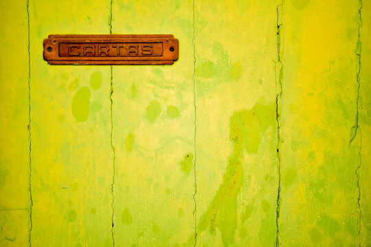 yellow door with a hole for mail