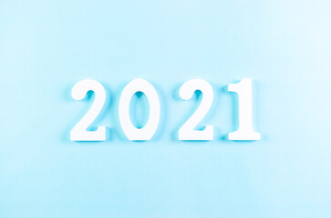 Top view of wooden numbers 2021 on pastel blue background. New year or Christmas concept.