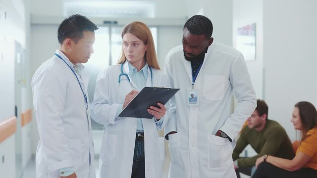 Diverse three multi-cultural doctors negotiating discussing therapy medication patients clinical records cooperating for better results. Medical staff. Collaboration concept.