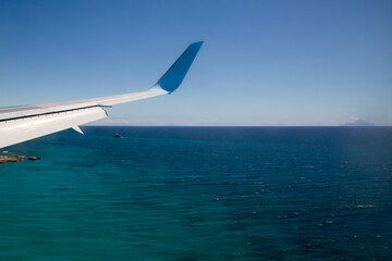 Naklejka premium Ausblick aus dem Flugzeug - Tragfläche und karibische Insel