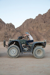 Fototapeta na wymiar Junges Mädchen auf riesigem Quad in der Wüste
