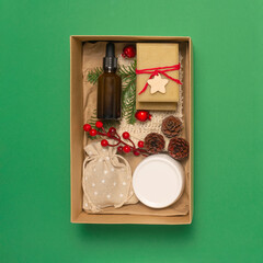 Present box with cosmetics on green background