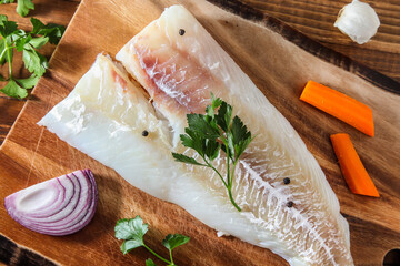 Alaskan cod fillet on cutting board with other ingredient
