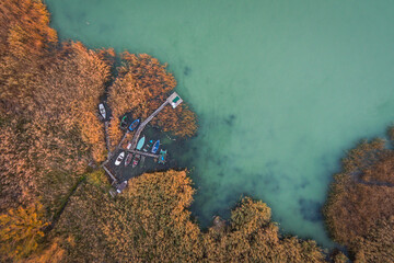 Colourful boats hiding in the harbor in the reeds from aerial birds-eye view