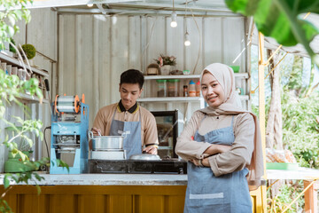 beautiful muslim woman entrepreneur at her small food stall smiling to camera