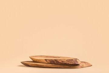 Wooden podium for cosmetic products, perfumes or food against beige background. Front view.