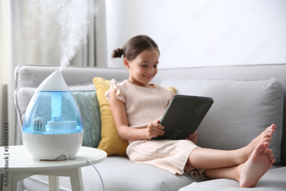 Sticker little girl using tablet in room with modern air humidifier