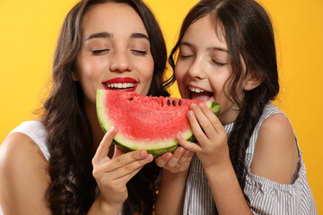 Happy girls with watermelon on yellow background
