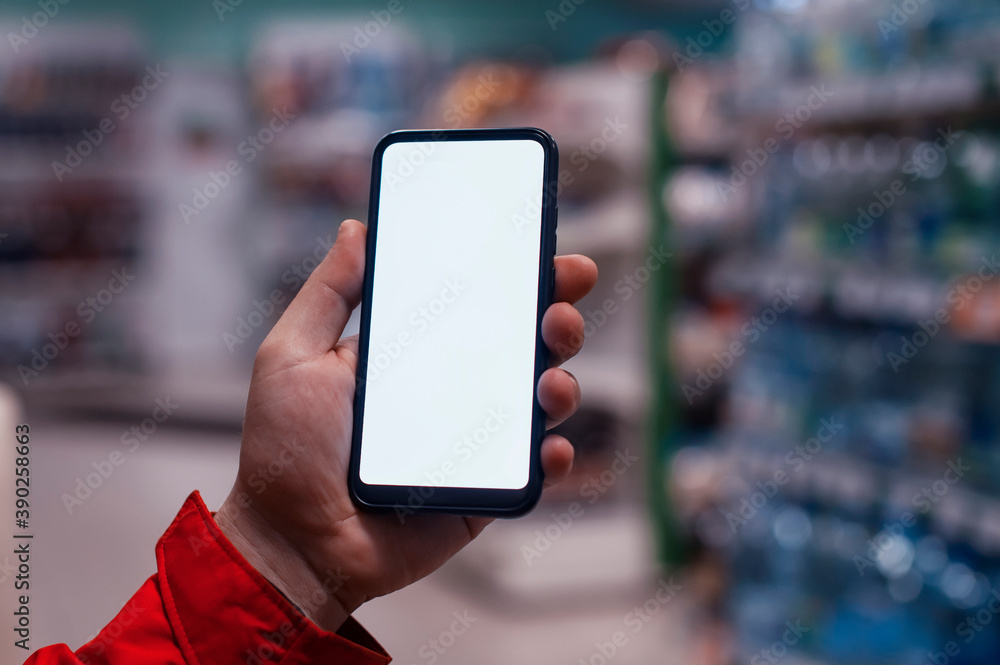 Poster mock-up of a smartphone with a white screen in the hands of a man. phone on the background of showca