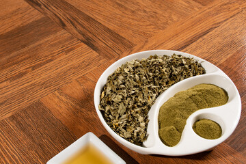 Moringa powder in wooden spoon - dried moringa leaves - moringa oleifera.
