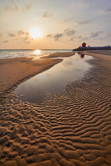 Strong natural patterns on Dutch beach during sunrise .
Scenic View Of Sea Against Sky During sunrise