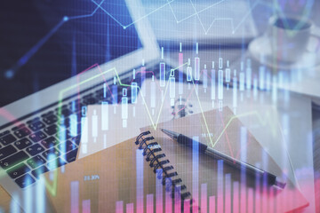 Double exposure of financial chart drawing and desktop with coffee and items on table background. Concept of forex market trading