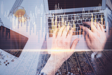 Double exposure of man's hands typing over laptop keyboard and forex chart hologram drawing. Top view. Financial markets concept.