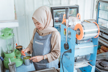 a asian beautiful woman is stirring the drink she is making in the shop