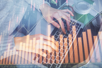 Double exposure of woman hands typing on computer and forex chart hologram drawing. Stock market invest concept.