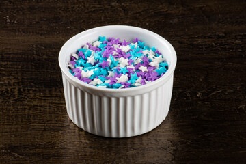 White bowl with granulated candy in the shape of stars.