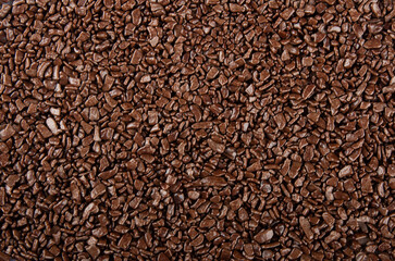Chocolate sprinkles background. View of granulated chocolate.