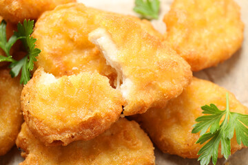 Tasty fried chicken nuggets on table, closeup