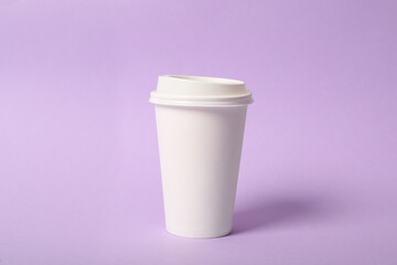 Takeaway paper coffee cup on violet background