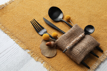 Autumn place setting with cutlery on white table, closeup