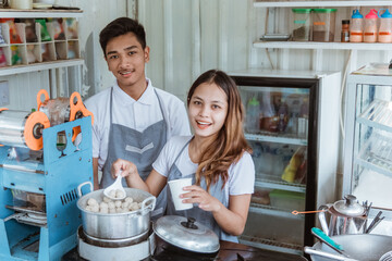 portrait young man and woman selling the dish meatball at her small shop