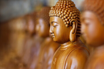 close up of wooden statue of buddha, in buddhist temple 