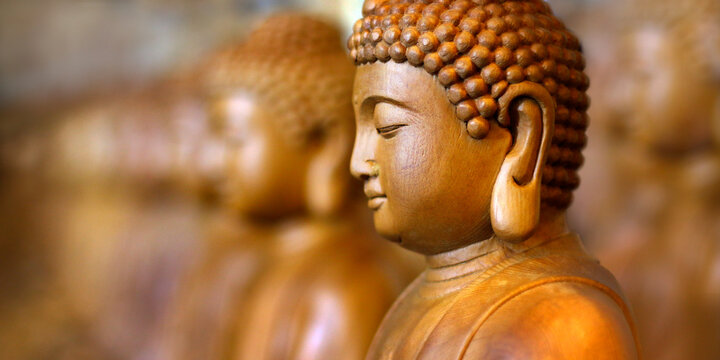 close up of wooden statue of buddha, in buddhist temple 