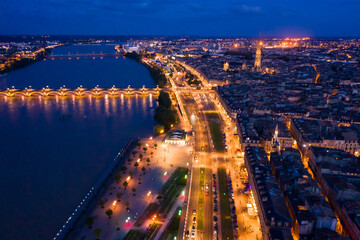 Fototapeta premium Panoramic aerial view of illuminated Bordeaux city on Garonne river at night