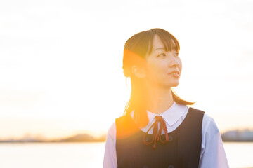 夕陽に包まれるアジア人女性の高校生