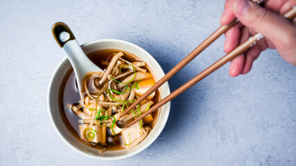 Hands holding Japanese mushroom soup