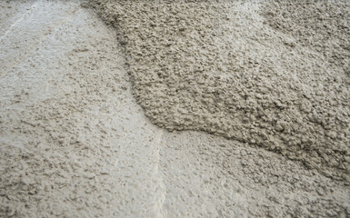 Texture of liquid concrete in road construction site.
Thick and condensed concrete.