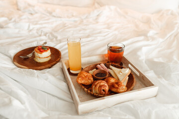 Breakfast in bed, a traywith tea. orange juice, pancakes, croissants, jam. Love message. Honeymoon. Early morning at the hotel