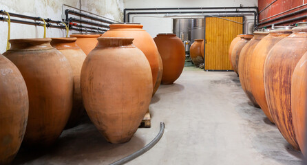 Wine cellar. Ceramic large jugs with wine in the cellar