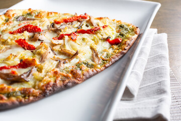 A view of a flatbread plate, featuring pesto and sun-dried tomatoes