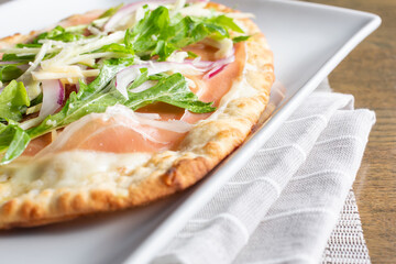 A view of a flatbread appetizer plate, featuring prosciutto.