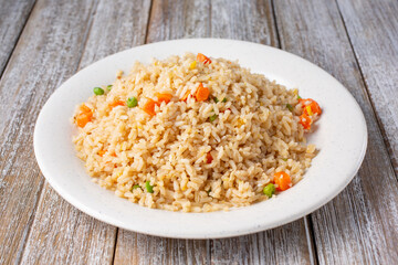 A view of a plate of fried rice, in a restaurant or kitchen setting.