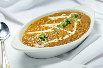 A view of a bowl of daal makhani, in a restaurant or kitchen setting.
