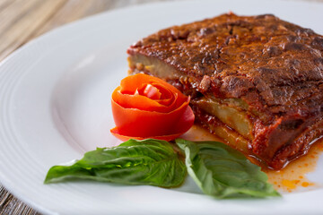 A view of a tomato rose garnish, part of a plate of Eggplant Parmigiana.