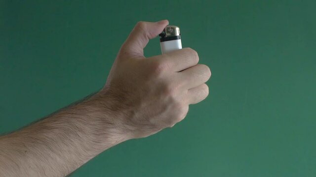 Young man turning on lighter in slow motion