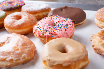 A view of an assortment of donuts  on a baking sheet.