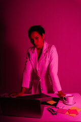 Business asian woman at working desk in red neon light.