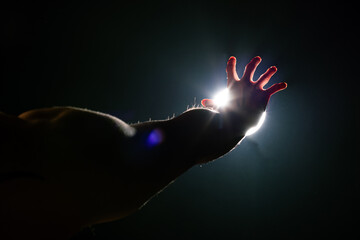 Man Hand grab reach Sun light as hope, future, light at end of tunnel