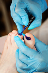 Process pedicure close up. Unrecognizable people. Master chiropody applying gel nail polish. Spa. Concept body care.