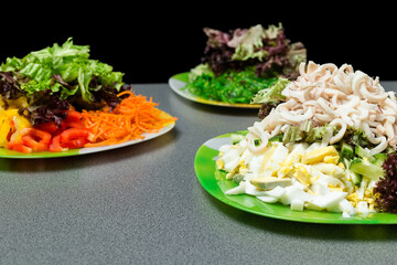 Ingredients for making salad on a green plate.