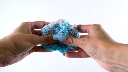 Female hands are molded from light airy multicolored blue plasticine, developing activities for children.