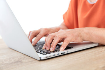 Closeup old man's hands typing enter on laptop keyboard
