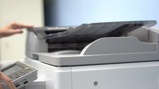Female workers are working on documents by copying documents with a multifunction copier machine.
