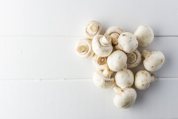 Fresh mushrooms champignon on a white wooden board.